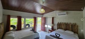 a bedroom with two beds and a window at Coco Paradiso in Mechapa