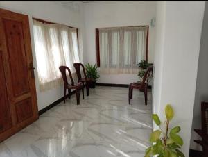 a room with chairs and a door and windows at White Shell in Tangalle