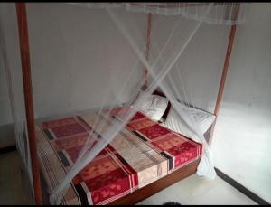 a bed with a canopy in a room at White Shell in Tangalle