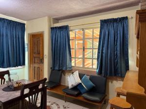 萨尔蒂约Departamento Nuevo Céntrico con vista hacia la catedral的客厅配有蓝色窗帘和桌椅