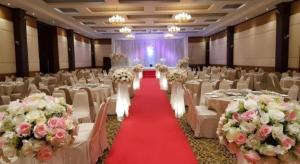 um salão de banquetes com mesas e cadeiras brancas em Western Grand Hotel Ratchaburi em Ratchaburi