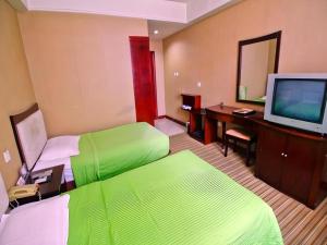 una camera d'albergo con due letti, una scrivania e una televisione di Super 8 Hotel Xian Nanshaomen a Xi'an