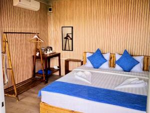a bedroom with a bed with blue and white pillows at kohrong sweet beach bungalows in Koh Rong Island