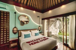 una camera da letto con un letto e una grande finestra di Aksari Villa Seminyak by Ini Vie Hospitality a Seminyak Altre 28 foto