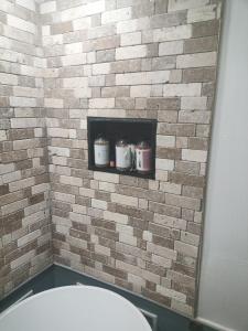 einen Spiegel im Bad mit Ziegelwand in der Unterkunft best one bed room close to parks and amenities in Cambridge