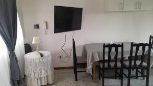 a room with a table with chairs and a flat screen tv at Namaste in Olavarría