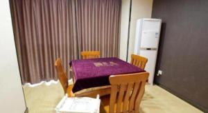 Una mesa con un mantel morado en una habitación. en 7 Days Premium Jingjiang Fuhai New World Automobile Terminal Branch, en Jingjiang