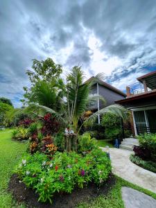 a house with a garden with flowers in the yard at BaanSuanklaiKlungBangkrachao บ้านสวนใกล้กรุงบางกะเจ้า in Phra Pradaeng