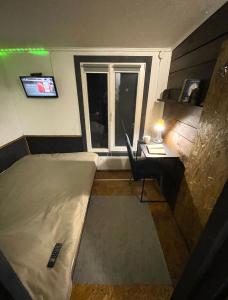 a room with a bed and a desk and a window at Scandinavia bungalow in Kamennaya Gora