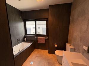 HarmanQuite and large 2 bedroom - Sleeps 6 - 2 bathrooms的带浴缸、马桶和水槽的浴室