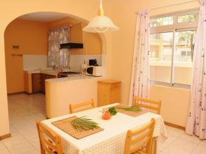 蓝海湾Villas Pingouin的一间带桌子的餐厅和一间厨房 更多21张照片