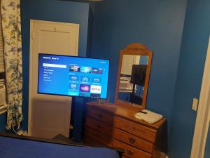 een slaapkamer met een tv en een dressoir met een spiegel bij 1052grovest in Irvington