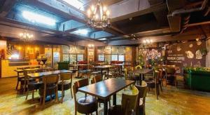 a restaurant with tables and chairs in a room at James Joyce Coffetel Xi'an Laochenggen Hongmiaopo Metro Station in Xi'an