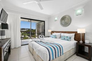 三一海滩蓝湖度假村的一间带大床的卧室和一个阳台 更多60张照片