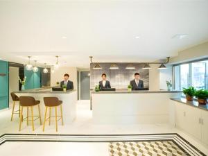 two men sitting at a bar in a restaurant at Magnotel Harbin Songbei Wanda Wenlvcheng in Harbin