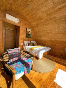 um chalé de madeira com 2 camas e um sofá em PHANSI - Glamping, View Point 360, Bar & BBQ em Sa Pa