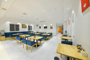 a dining room with tables and blue chairs at PAI Hotel·Luoyang Dingding Bei Road Hongjin Logistics International Peony Garden in Luoyang