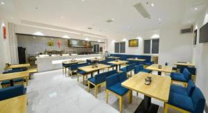 a restaurant with wooden tables and blue chairs at PAI Hotel·Luoyang Dingding Bei Road Hongjin Logistics International Peony Garden in Luoyang