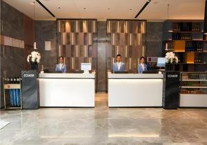 three people sitting at the counter of a salon at Echarm Hotel Jinan West Station International Exhibition Center in Jinan