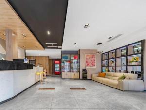 Una gran sala de estar con un sofá y un bar. en Borrman Hotel Tai'an Central Hospital Taishan Tianwai Village Hongmen, en Tai'an