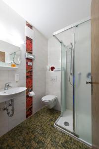 a bathroom with a shower and a toilet and a sink at Hotel zum Rehberg in Kastellaun