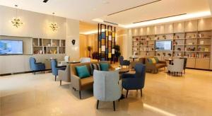 um lobby de hotel com cadeiras e mesas em Echarm Hotel Liuzhou Liunan Wanda Plaza em Liuzhou