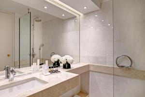 a bathroom with a sink and a large mirror at Divani Caravel in Athens