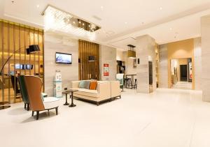 a lobby with a couch and a table and chairs at City Comfort Inn Nanning Taoyuan Road in Nanning