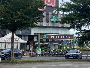 Phú MỹNha Nghi Phu Gia的建筑物前停放汽车的停车场