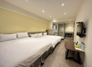 un grande letto bianco in una stanza con televisore di 逢甲Cartoon a Hsia-shih-pi