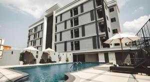 a building with a swimming pool in front of a building at B2 Amata Nakorn Premier Hotel in Ban Chak Samo