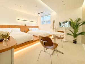 a bedroom with a bed and a table and chairs at 이루다스테이 호텔 고척돔점 in Seoul