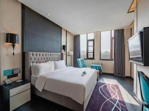 Ένα ή περισσότερα κρεβάτια σε δωμάτιο στο Xana Hotelle Luzhou High-Speed Railway Station Trading Market Passenger Terminal