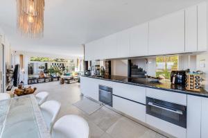 una cucina con armadi bianchi e una sala da pranzo di Spacious 3-Bedroom Villa in Montreux a Blonay