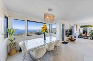 una sala da pranzo con tavolo, sedie e finestre di Spacious 3-Bedroom Villa in Montreux a Blonay