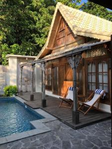 克罗柏坎Villa Bliss - 1BR Tropical Villa in Kerobokan的一个带两把椅子的凉亭和一个游泳池