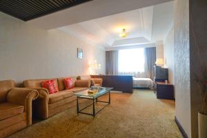 秦皇岛秦皇岛羊城酒店的带沙发和桌子的客厅