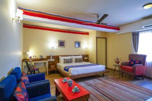 a hotel room with a bed and two chairs at Open Hotel by Olive - Utse Suites in Bengaluru