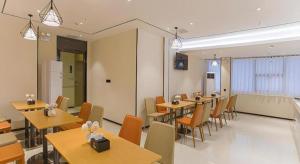 a dining room with wooden tables and chairs at City Comfort Inn Wuzhou Sun Plaza Wanda in Wuzhou