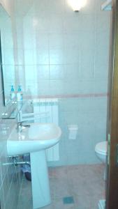 Baño blanco con lavabo y aseo en Affittacamere La Casella, en Gallo