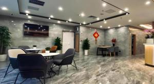 济南Shell Hotel Shandong Jinan Daming Lake的大楼内配有桌椅的大厅