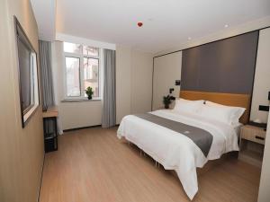 a large bedroom with a large bed in it at Green Tree Inn Express Tangshan Kaiping District Government in Dachadao +175 photos