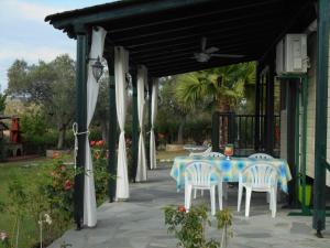 a patio with a table and chairs under awning at Heliactida House in Ormos Panagias