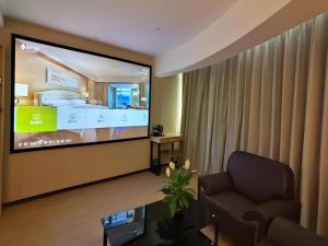 a room with a large screen television in a hotel room at Green Tree Inn Express Tangshan Kaiping District Government in Dachadao