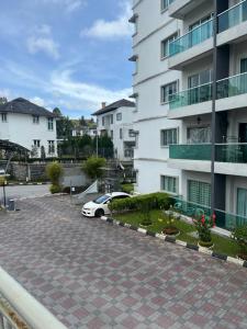 Un coche aparcado en un aparcamiento junto a un edificio. en Imagine world quintet apartment, en Tanah Rata