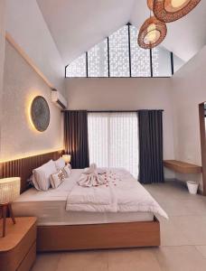 a bedroom with a large bed with a large window at Villa Jasmine in Seminyak