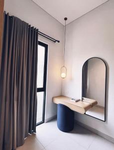 a dressing table and mirror in a room with a window at Villa Jasmine in Seminyak