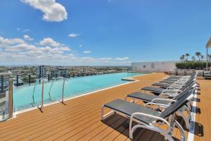 a row of lounge chairs on the roof of a building at Riverside Modern Living 2B2B Apt with Parking in Brisbane