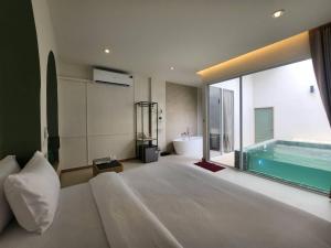 ein Schlafzimmer mit einem großen Bett und einem Swimmingpool in der Unterkunft Villa38 in Pathum Thani