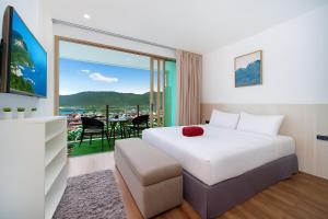 a hotel room with a bed and a balcony at Studio Apt Seaview Balcony - Oceana C63 in Kamala Beach +8 photos